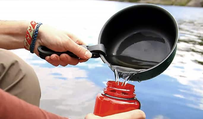  Person pouring boiled water into a bottle  