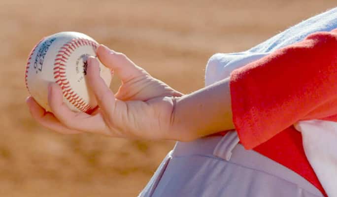 Une personne tenant une balle de baseball
