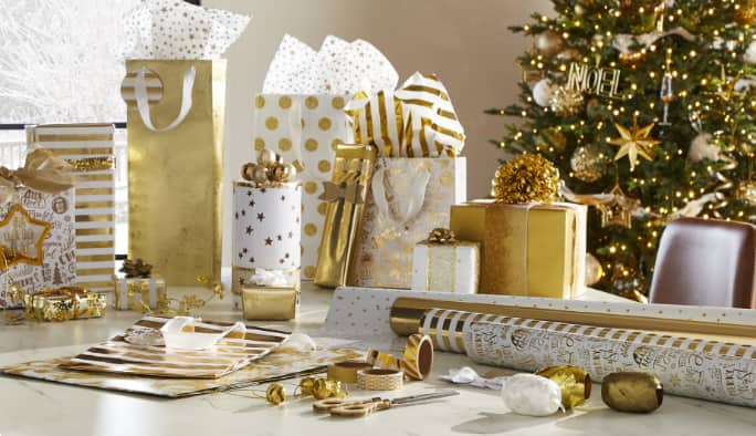 Gold Gatherings gift wrap and gift bags on a counter