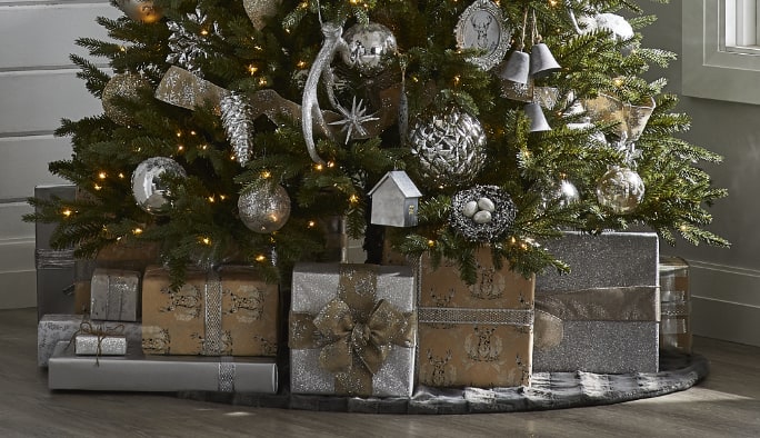 Cadeaux de Noël enveloppés avec du papier d’emballage de la collection Argent scintillant CANVAS sous un sapin