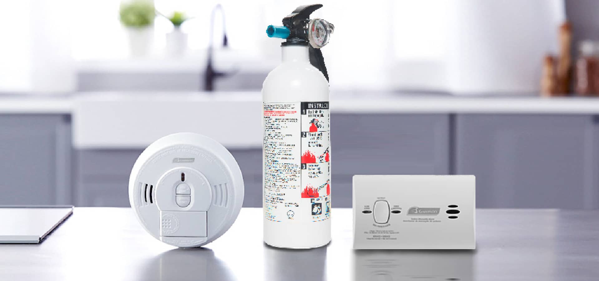 Smoke alarm, fire extinguisher and CO alarm on kitchen counter 