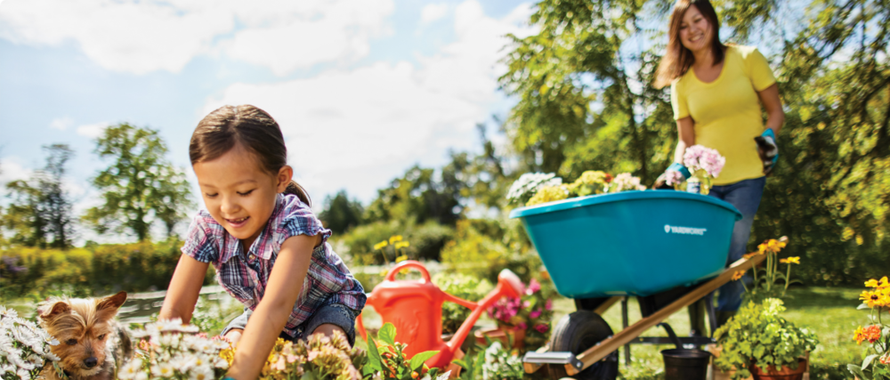 Mother and daughter planting flowers and gardening outdoors