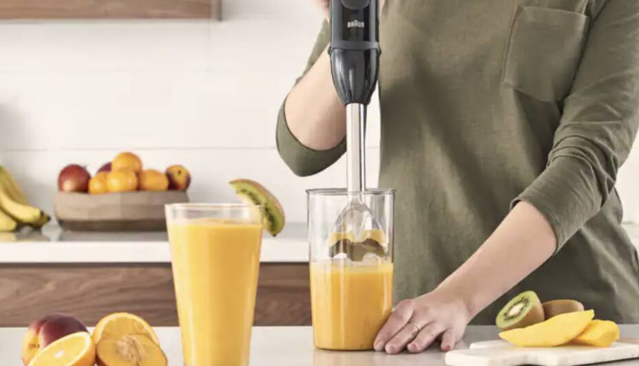 Person using immersion blender to make a smoothie