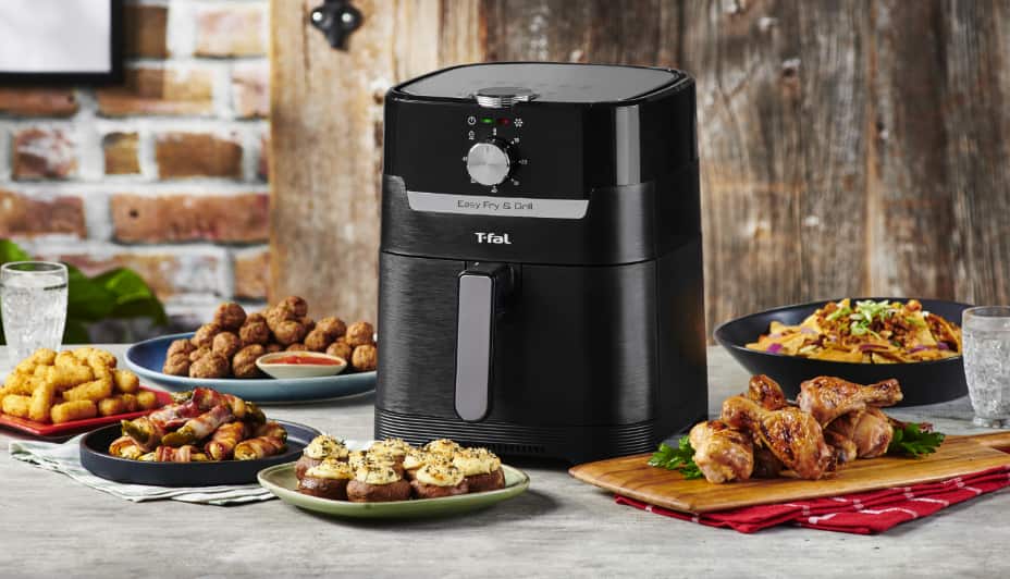 Ultima Cosa Air Fryer beside a variety of appetizers 