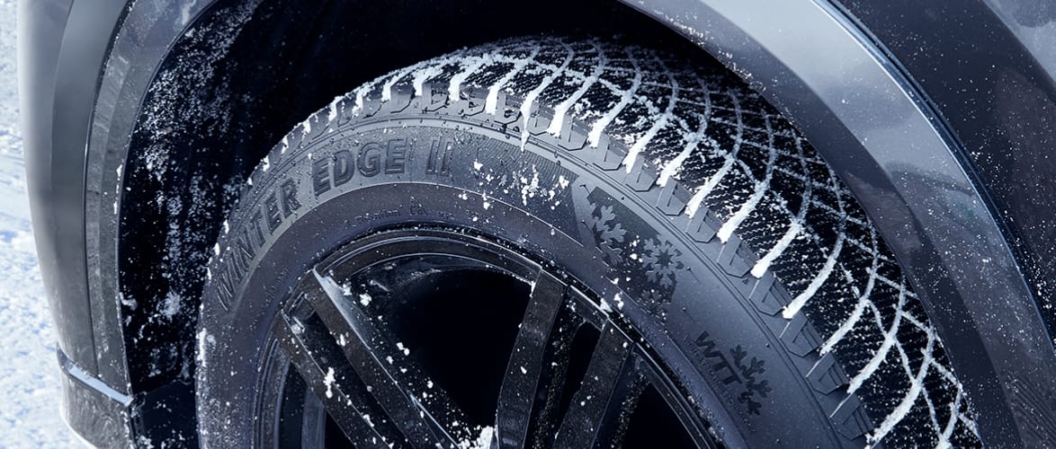 Un pneu MotoMaster Winter Edge II avec des traces de neige dans les bandes de roulement.
