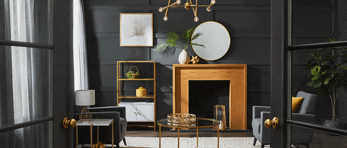 A stylish black living room featuring gold-accented furniture, decor, light fixtures and door hardware.