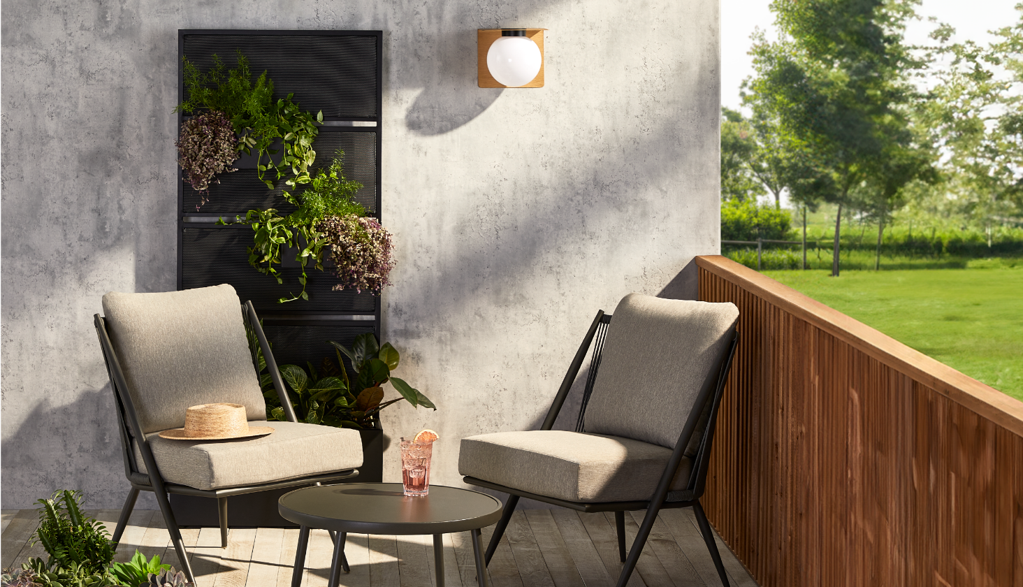 A CANVAS Mercier Privacy Screen planter, 3-pc Nero Chat Set and a NOMA Wall Mounted Light on a patio.
