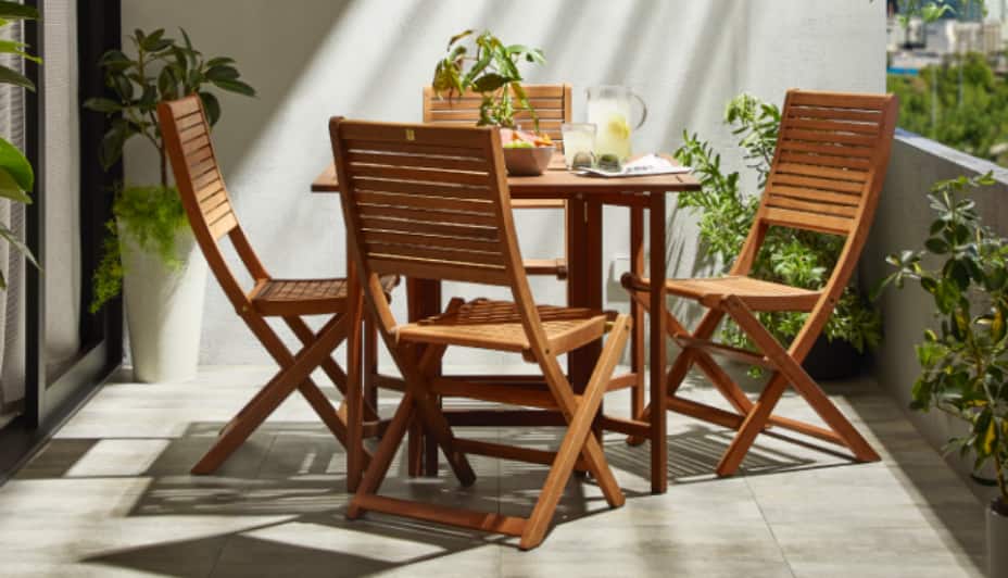 A 5-piece wooden CANVAS Sherbrooke Dining Set on a balcony. 