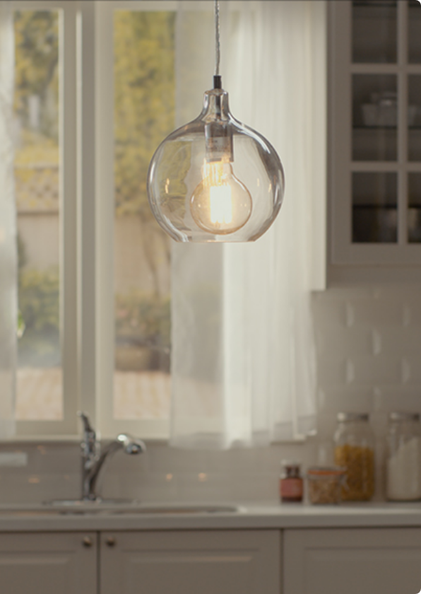 Two hanging ceiling lights with glass covering around bulbs