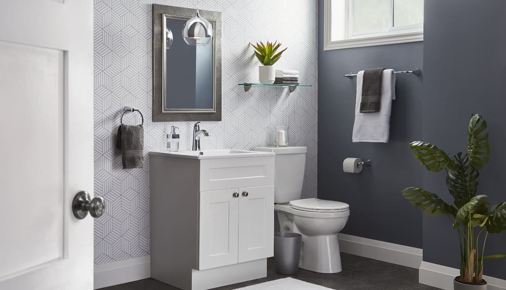 A stylish grey bathroom with chrome design elements, including a mirror, faucets and a towel rod.