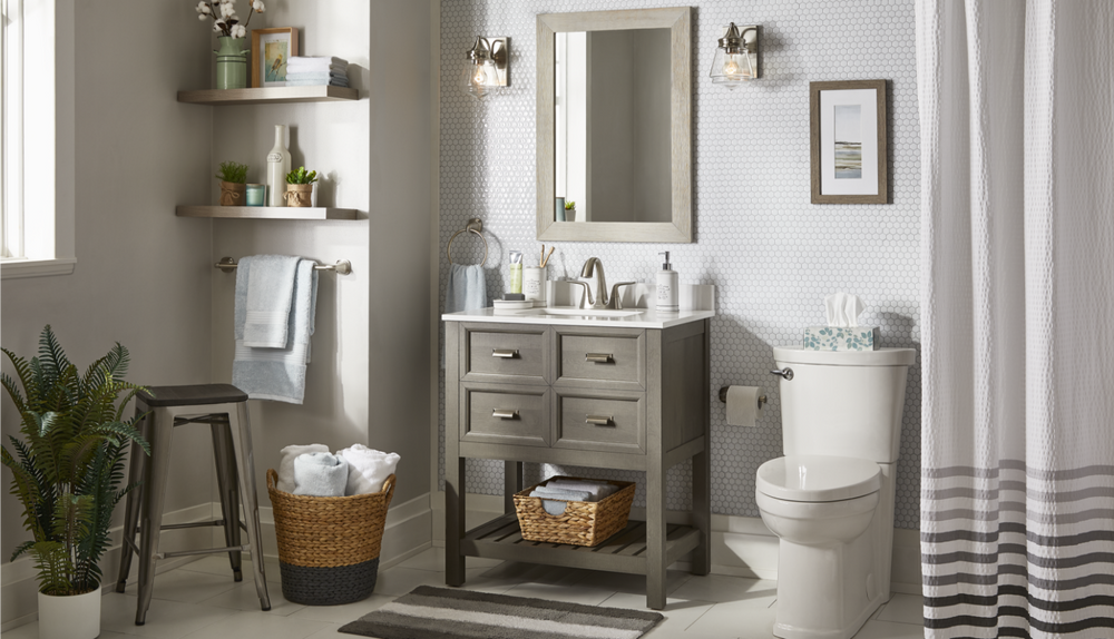A white-and-grey rustic look bathroom with brushed nickel design elements, including light fixtures, a vanity and a stool.