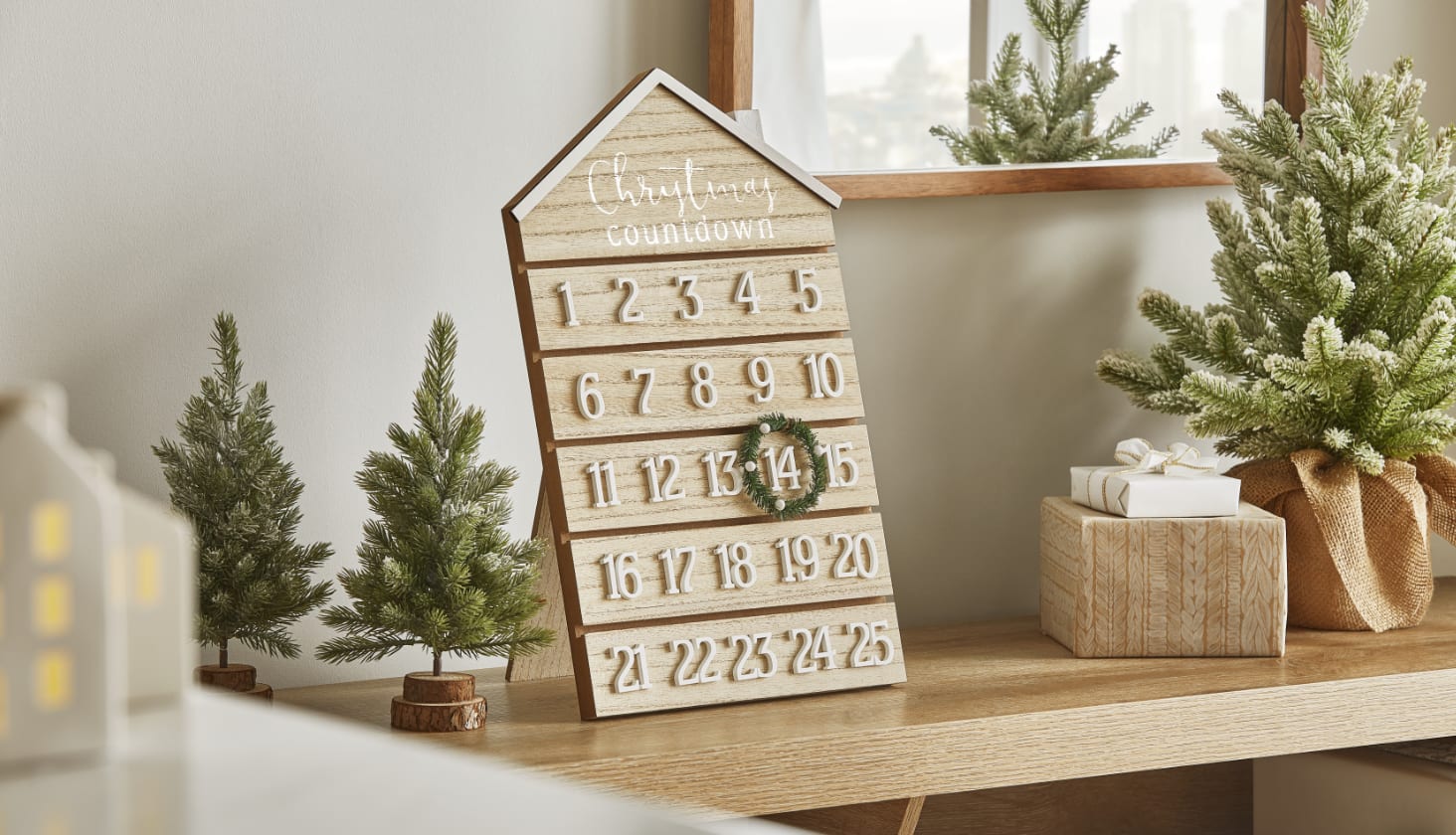 CANVAS wooden advent calendar on table beside mini tabletop trees