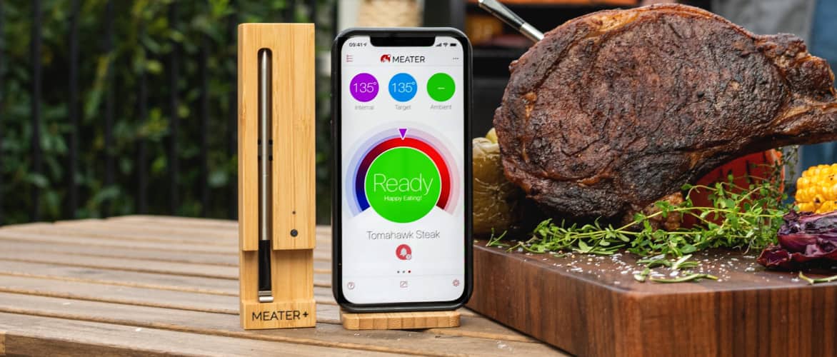 A MEATER Wireless Smart Thermometer and App on a smart phone next to a cooked roast.
