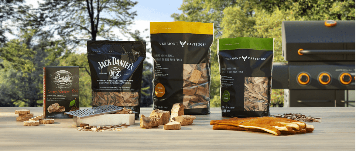 A variety of packaged wood chips, pellets and accessories on an outdoor table. 