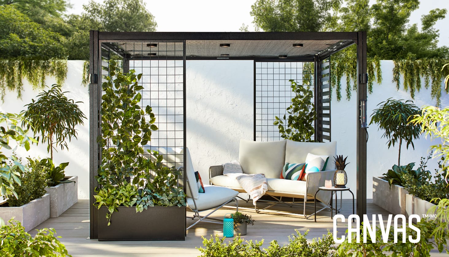 CANVAS Horizon Pergola with plants and  CANVAS Banks Sofa Seats in a backyard.