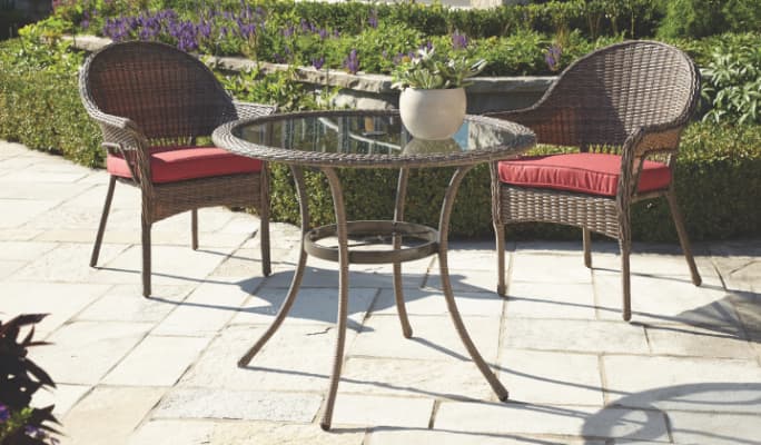 CANVAS Canterbury Collection dining table and two chairs on a garden patio.