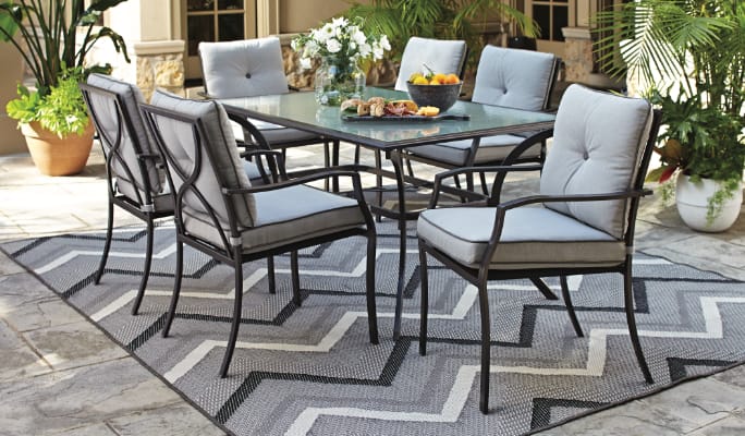 CANVAS Bluebay Dining Set on patio with 6 cushioned dining chairs and table.