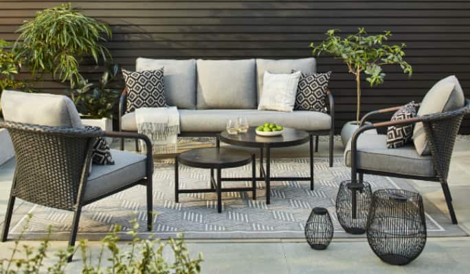 CANVAS Jasper Collection loveseat, armchairs and nesting tables on a patio.