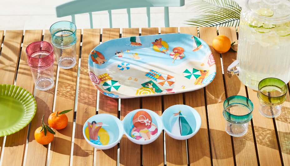 An assortment of For Living Bright Beach Serveware and a beverage dispenser on a table. 