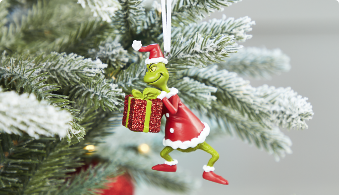 Grinch Ornament hanging on Christmas tree.