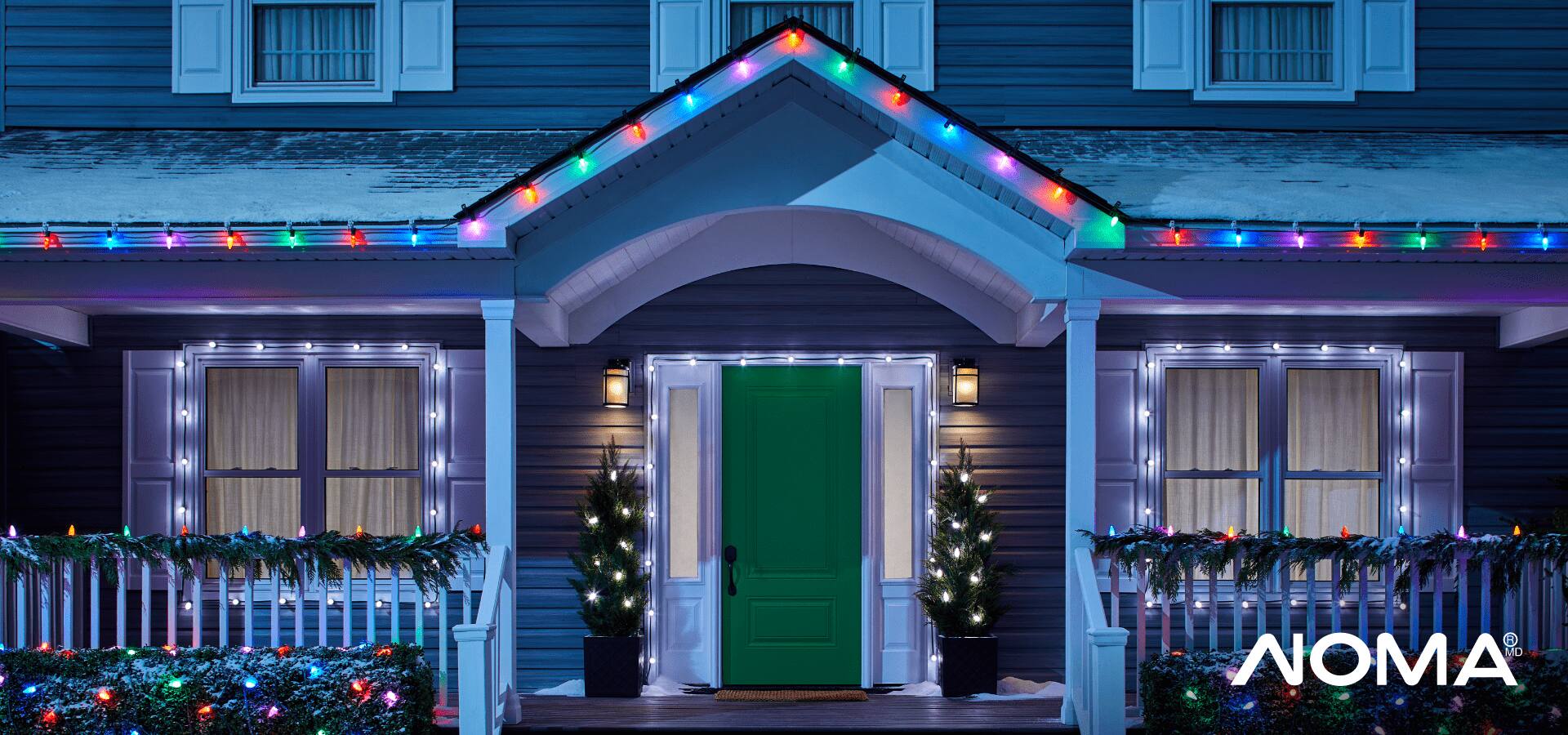 A house decorated with multi-coloured, glowing Christmas lights. 