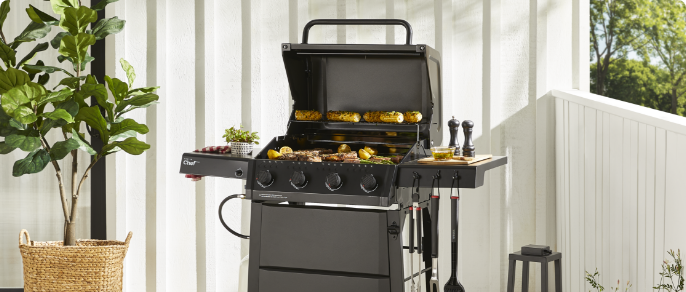 MASTER Chef Discover 4-Burner Propane BBQ grilling steaks and veggies outside.