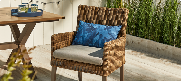 CANVAS Belwood Dining Chair on wooden backyard porch with a cushion seat and throw pillow.
