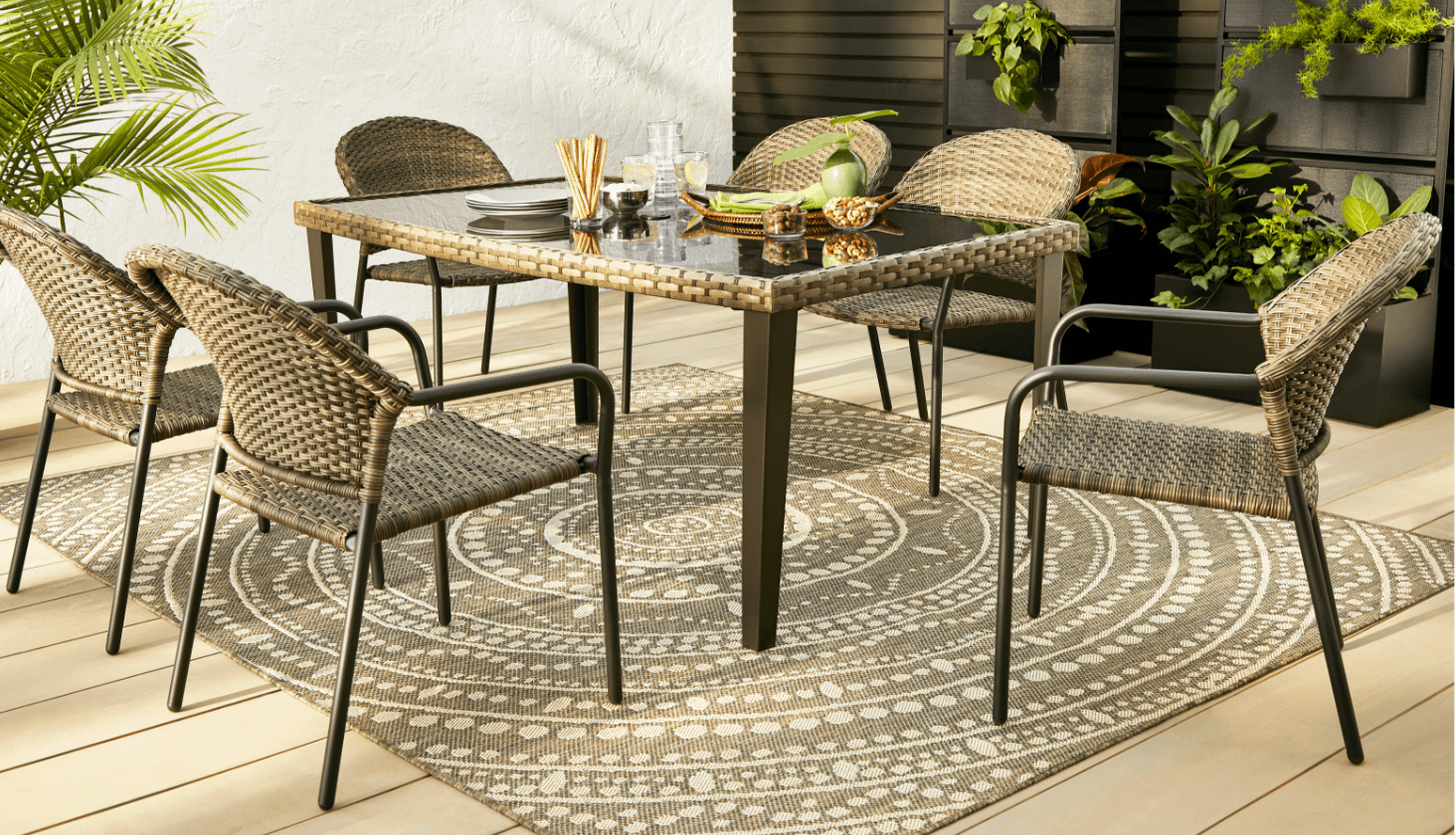CANVAS Breton Dining Table on backyard patio with 6 wicker bistro dining chairs.