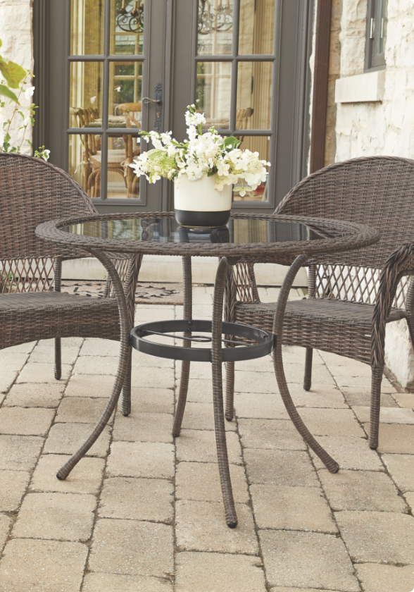  Une table à manger CANVAS Canterbury avec deux chaises à dîner sur un patio. "