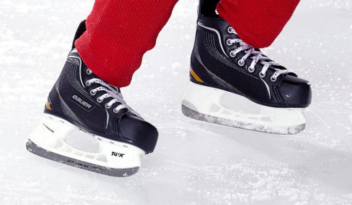 Une personne patinant sur la glace avec des patins de hockey Bauer.