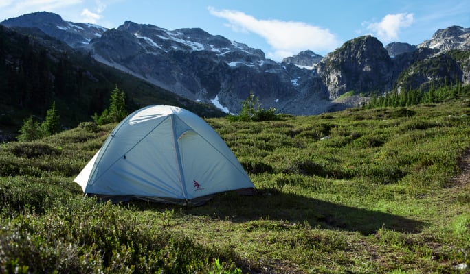 A WOODS cascade tent pitched in a mountainous landscape. 
