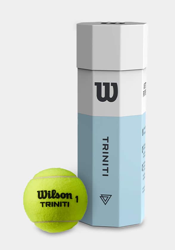 Une balle de tennis Wilson Triniti à côté de son emballage octogonal en papier.