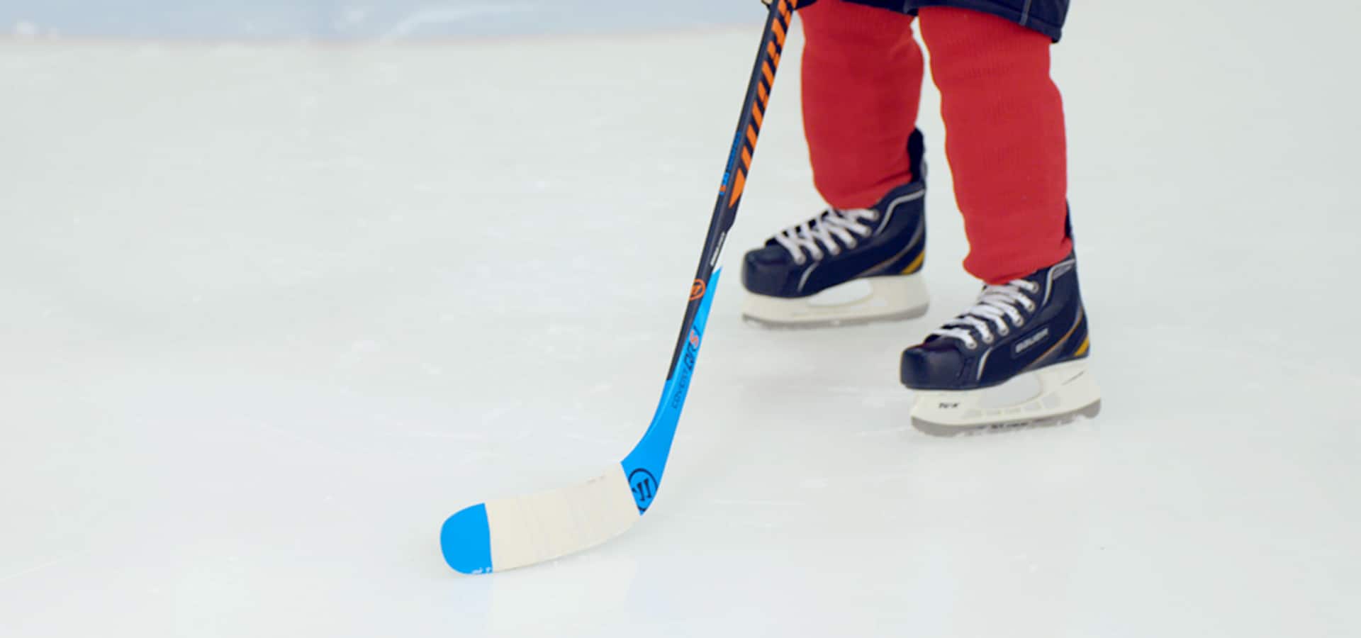 Un enfant joue au hockey sur une patinoire