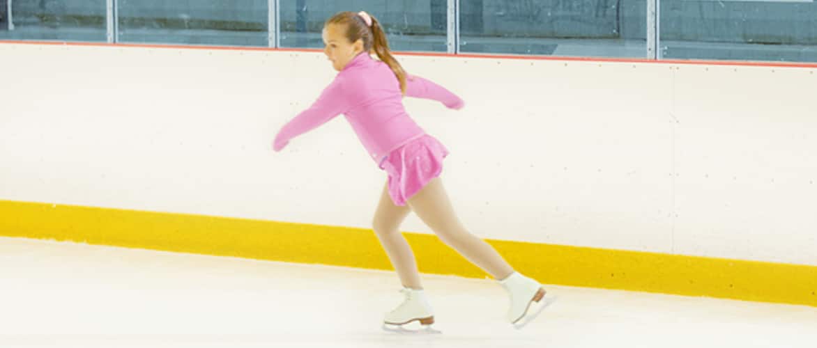 Une jeune fille pratiquant le patinage artistique sur une patinoire.