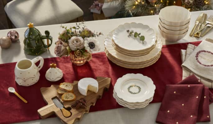 Assiettes, serviettes et plateau de fromages sur une table de Noël