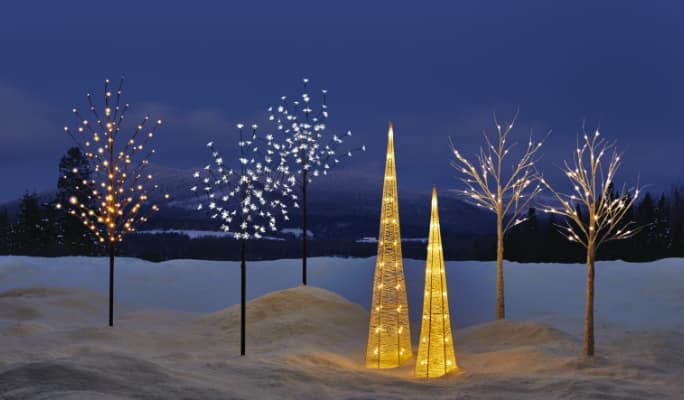 CANVAS pre-lit Outdoor Tree Collection displayed on a snowy front lawn