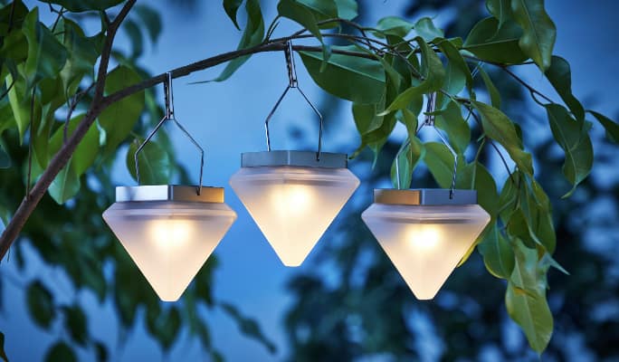 Three glowing Geometric Lights hanging on a tree branch. 