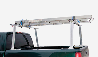 An aluminum ladder strapped to a cargo rack mounted in a pickup truck’s bed.