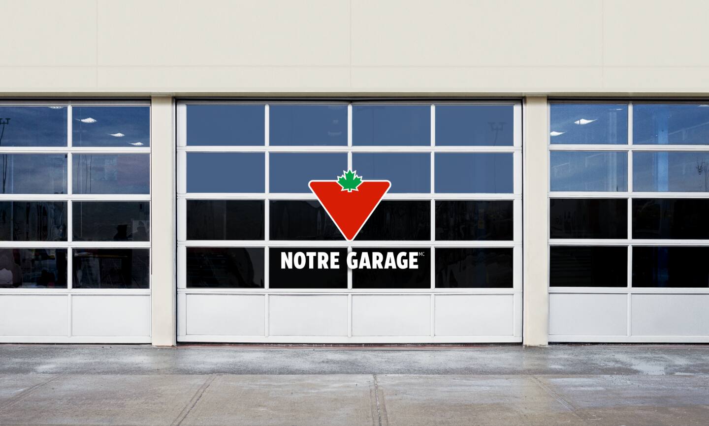 Le logo de «Notre garage» devant une rangée de portes de l'aire de service.