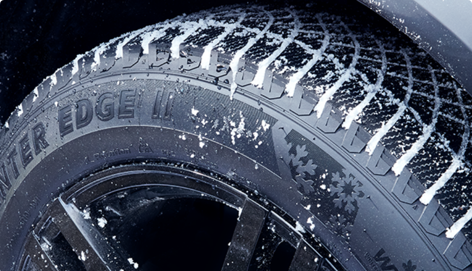 A MotoMaster Winter Edge II tire with snow in its treads.