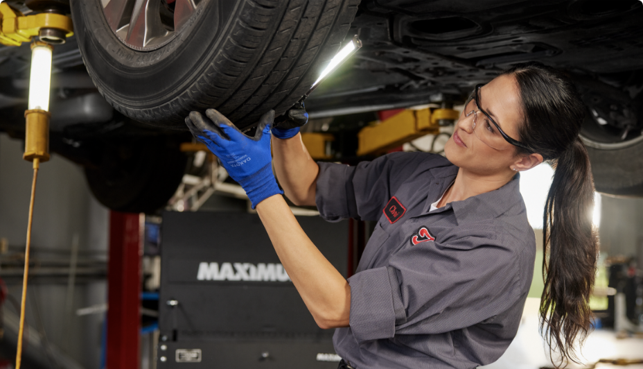 A Canadian Tire Auto Service technician checks a car’s tire.