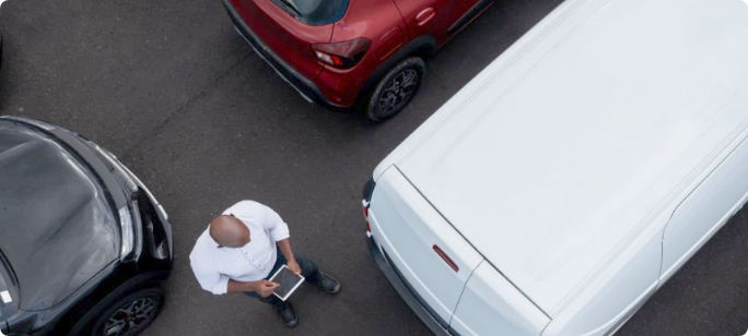 A man inspects vehicles in a commercial fleet.