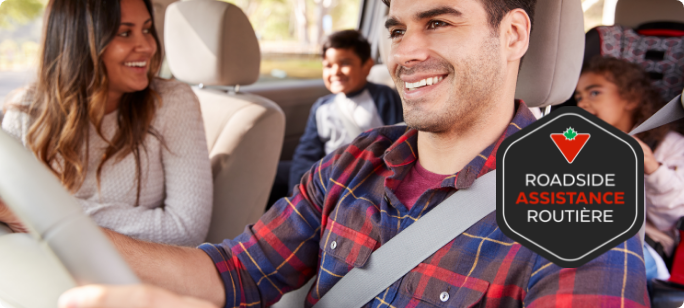 Un homme au volant d'une voiture tandis que des enfants sourient sur le siège arrière.
