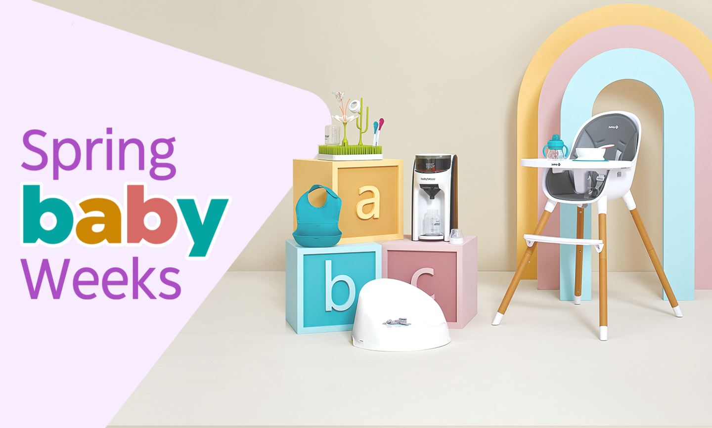 A selection of baby products displayed on and around three giant letter blocks.