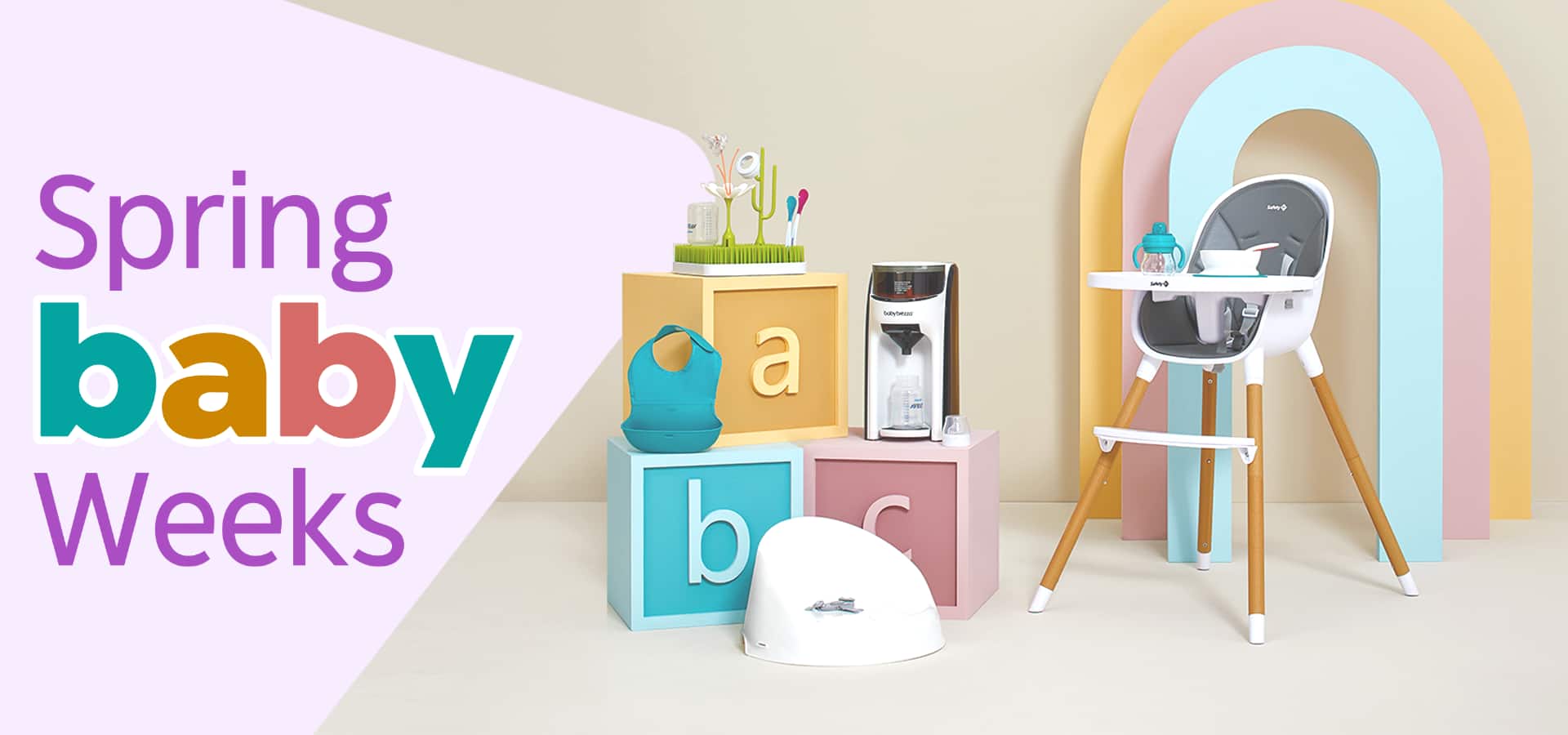 A high chair, potty, activity center and other baby products displayed on and around three giant letter blocks.