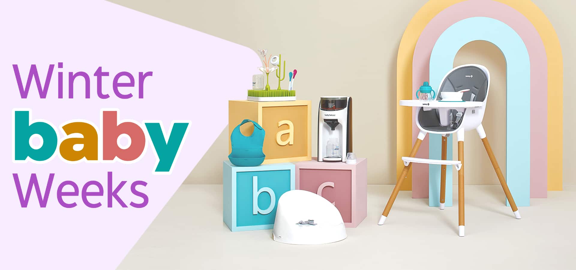 A high chair, potty, activity center and other baby products displayed on and around three giant letter blocks.