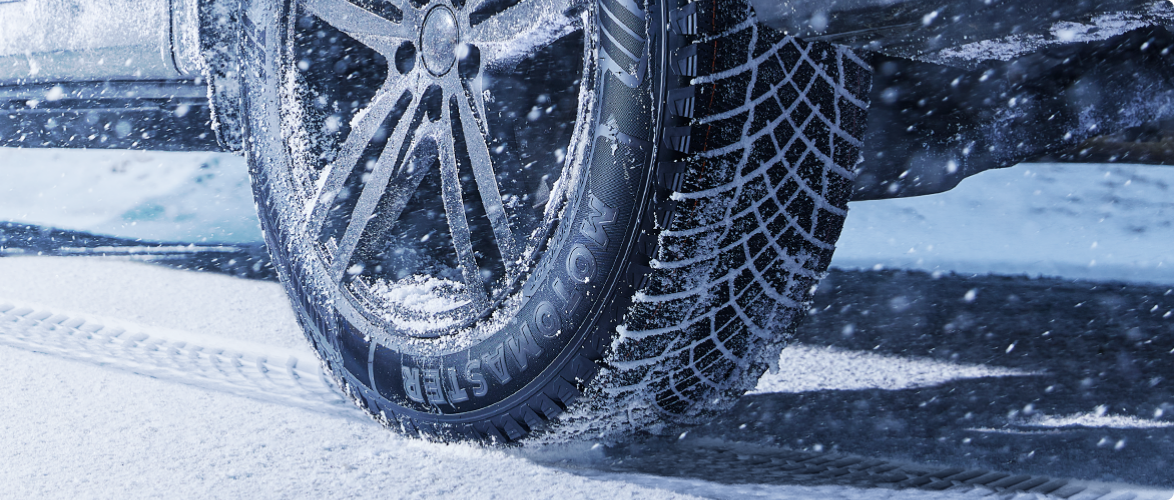 A car equipped with MotoMaster tires on a snowy road.