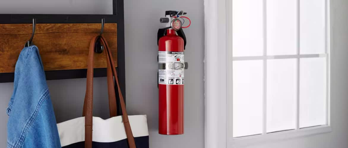 A fire extinguisher hangs in the hallway of a home.