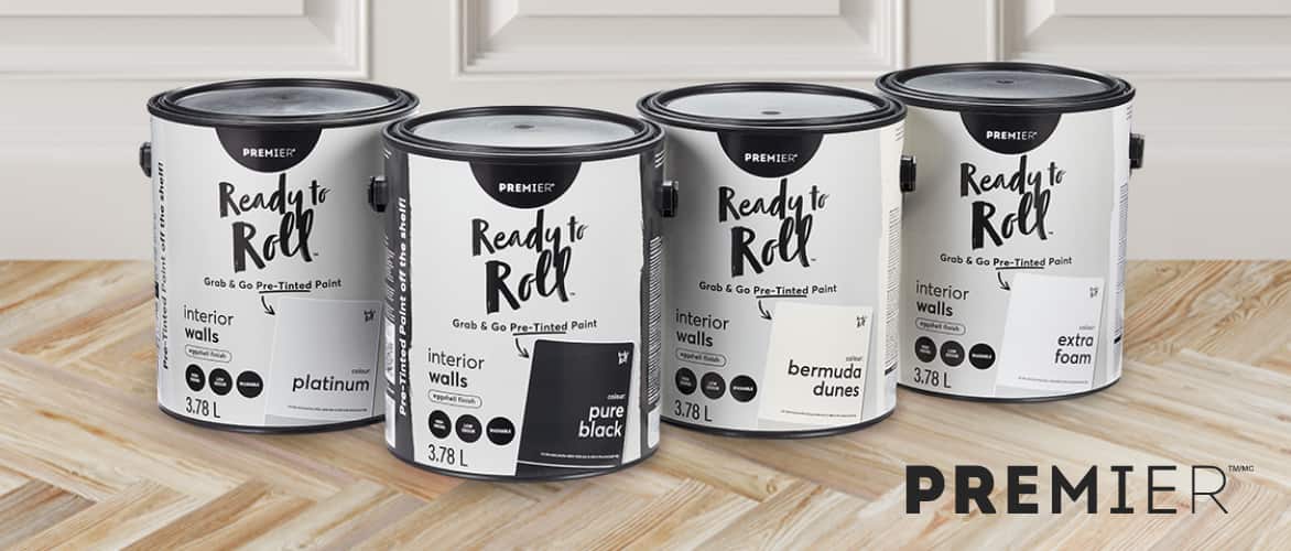 Four cans of assorted Premier Ready to Roll paint on a hardwood floor.