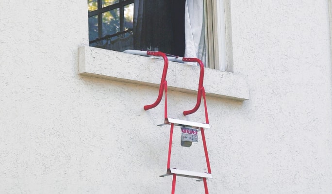 A rope ladder hangs out of an open window.